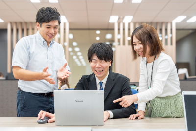 PCを前に話をしている3人のスタッフ